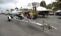 Picture of Tandem Axle Boat Trailer on Concrete. Boat in the background.